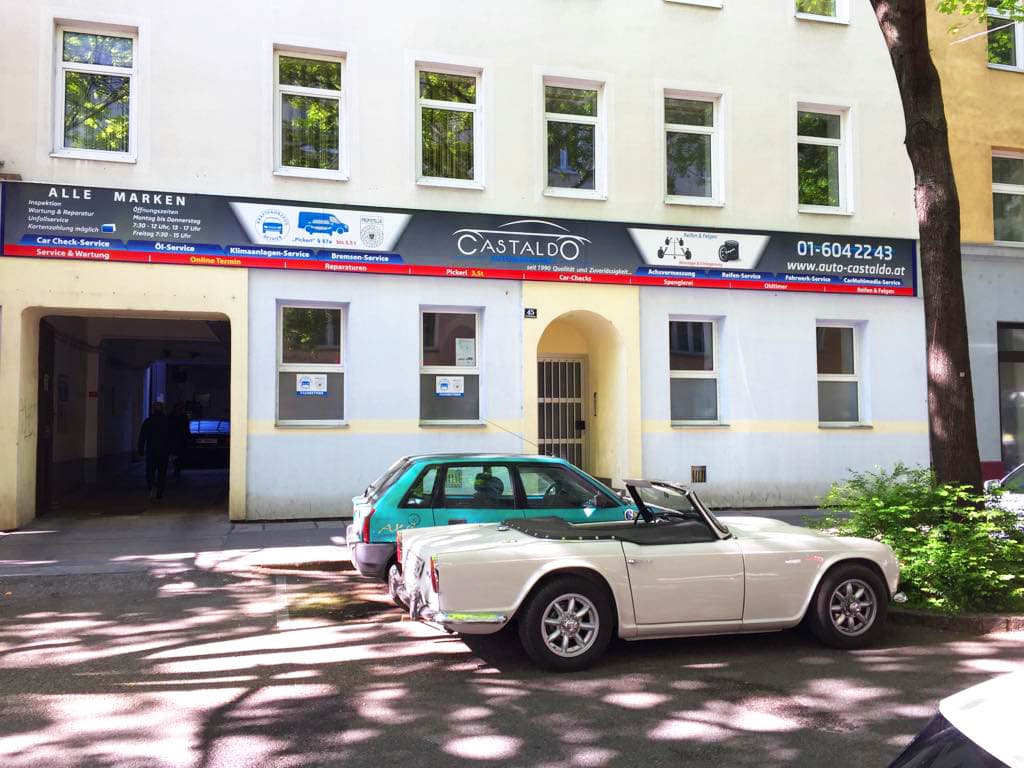 Fassade von Auto Castaldo, Puchsbaumgasse 45, mit Triumph-Oldtimer davor